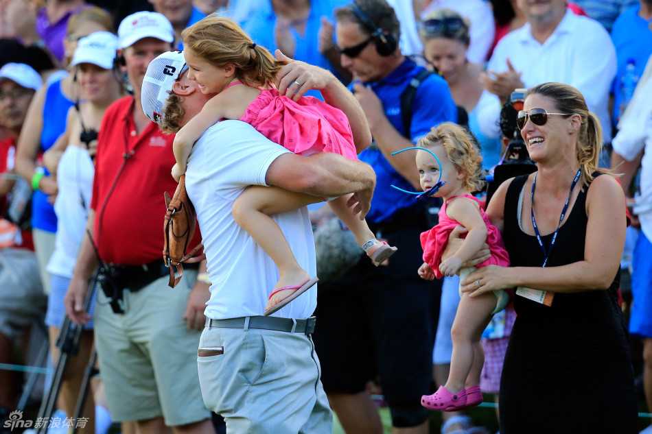 果岭上的家庭庆典:霍夫曼的冠军时刻与深情拥抱 颁奖典礼上,查利·霍夫曼高高举起OHL精英赛的冠军奖杯,银色奖杯在聚光灯下闪耀,背景是墨西哥玛雅科巴的美丽夜色。