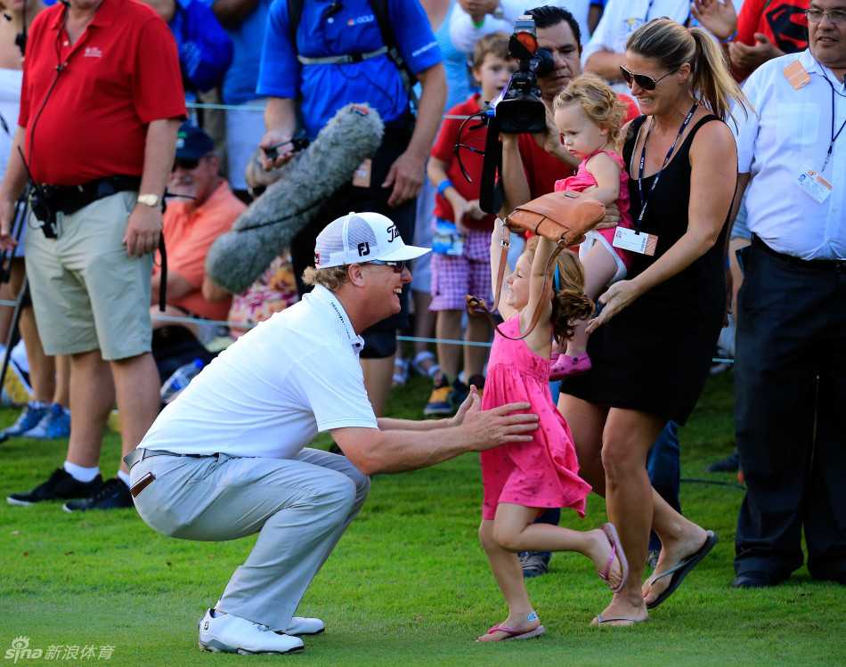 果岭上的家庭庆典:霍夫曼的冠军时刻与深情拥抱 霍夫曼的大女儿兴奋地围绕在父亲身边手舞足蹈,霍夫曼则满眼宠溺地看着女儿,果岭瞬间变成了他们的欢乐舞池。