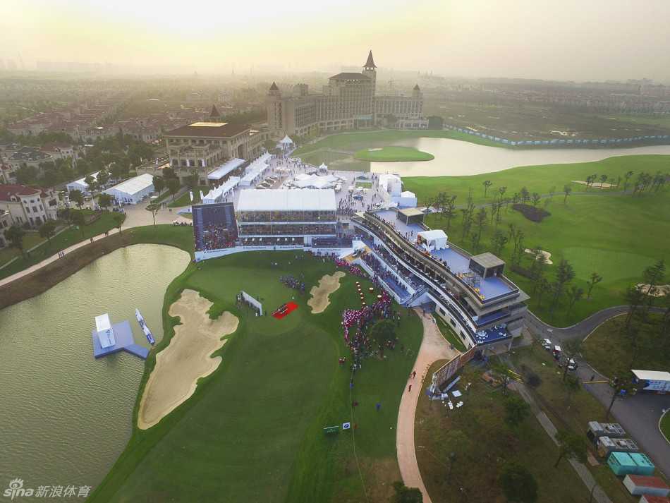 俯瞰视角下的第14洞果岭，蜿蜒的球道在夕阳下划出优雅的曲线，与远处的湖水相映成趣。