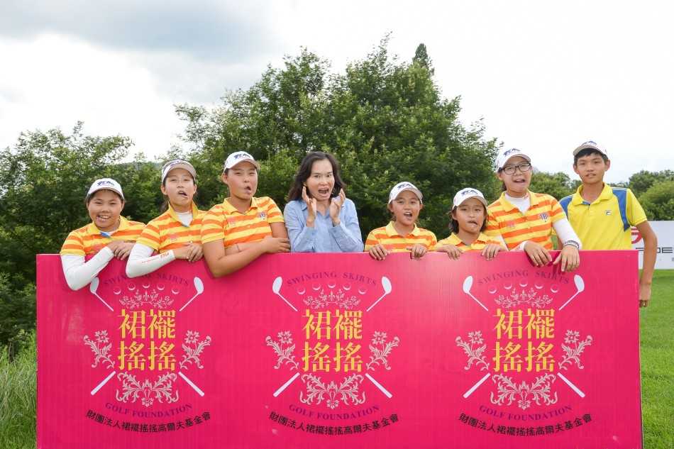 国际友人的专注开球：一位金发碧眼的德国小选手沉稳地站上发球台，目光锐利地望向远方的球道，准备打出漂亮的一击，展现了高尔夫运动的国际性与包容性。