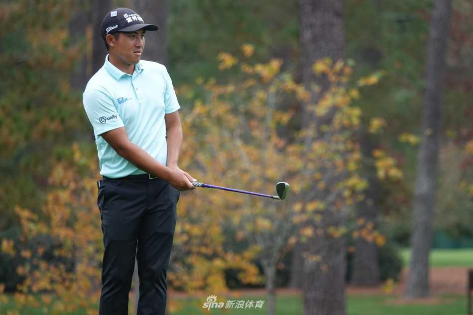 潘政琮在奥古斯塔果岭边仔细研究推杆线路，评估草纹与坡度对小白球的影响。