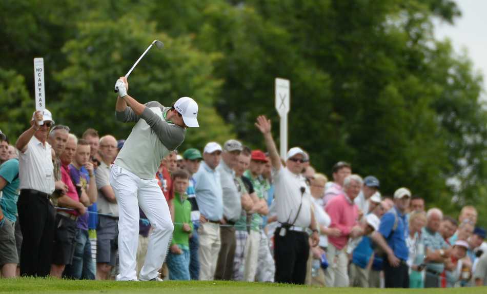 一位戴着鸭舌帽的球员在果岭边，全神贯注地准备处理一个困难的切球，寻找最佳的救球路线。