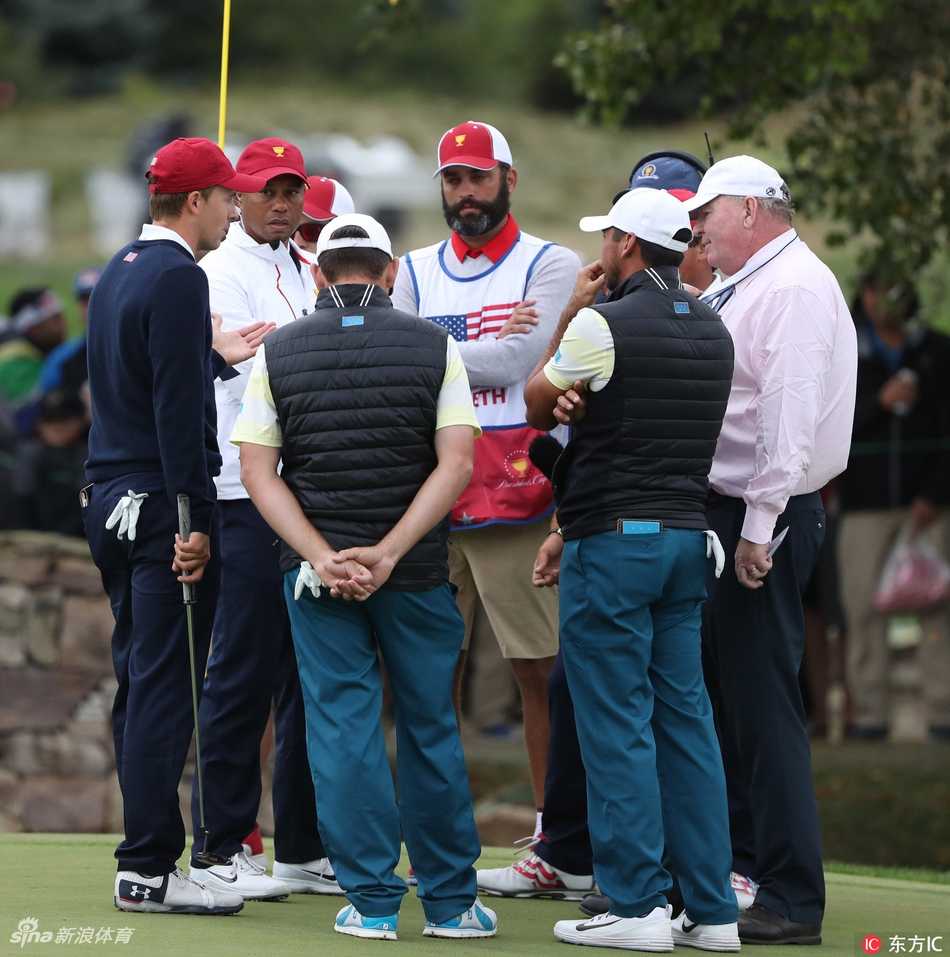 达斯汀·约翰逊在果岭边凝神观察推杆线路，身旁的布鲁克斯·科普卡目光坚定，这对强大组合的震慑力弥漫全场。