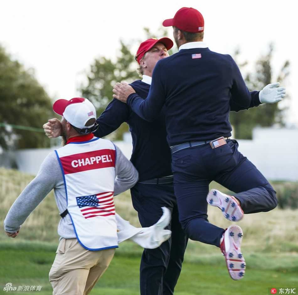 贾斯汀·托马斯在果岭上成功推入一记关键推杆后，兴奋地高举双臂庆祝，脸上洋溢着释放的喜悦与激情。