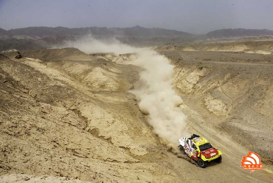 2023环塔拉力赛排位赛首日，赛车在阿克苏月亮泊的戈壁滩上卷起滚滚烟龙，如利剑般划开沉寂大地，向着天际线疾驰而去。