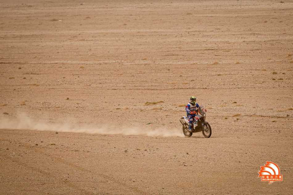 一辆蓝色赛车冲过终点线，车身覆盖着厚重的泥土与沙尘，如同凯旋战士的勋章，诉说着征途的艰辛与荣耀。