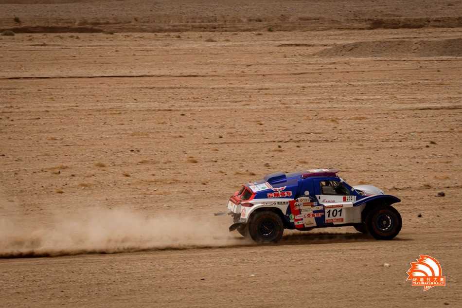 维修区内，技师们正在紧张地对赛车进行检修，专注的神情与专业的工具在灯光下交织，他们是车手征服荒野最坚实的后盾。