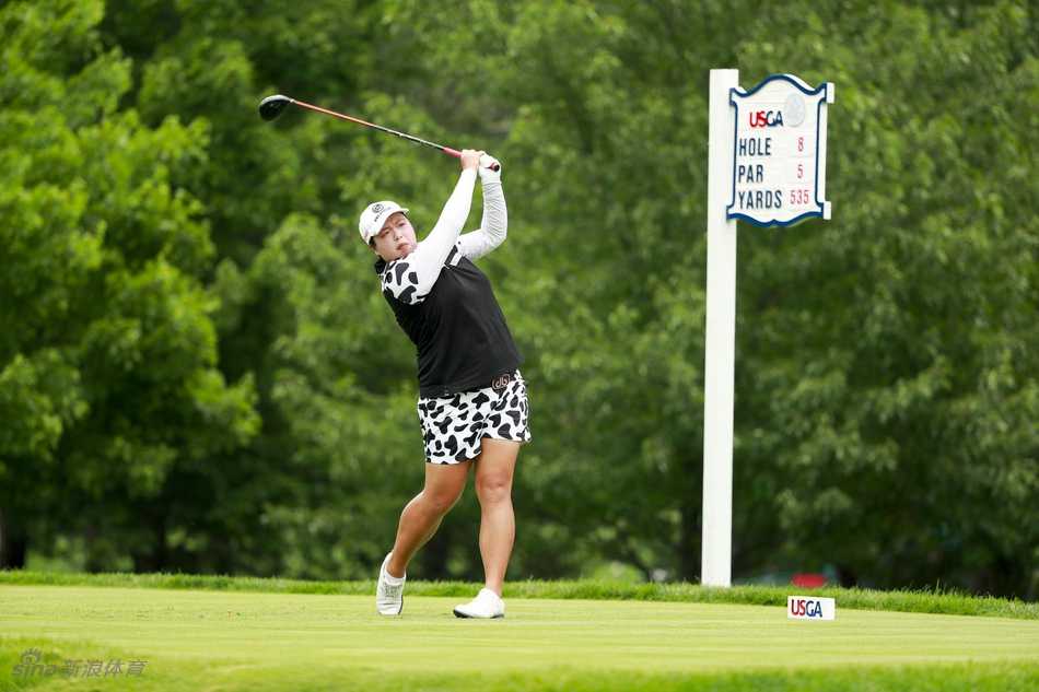 魏圣美一记有力的开球动作瞬间，她身着明亮的黄色上衣，在绿色球场的映衬下格外醒目，球杆挥出完美的弧线。