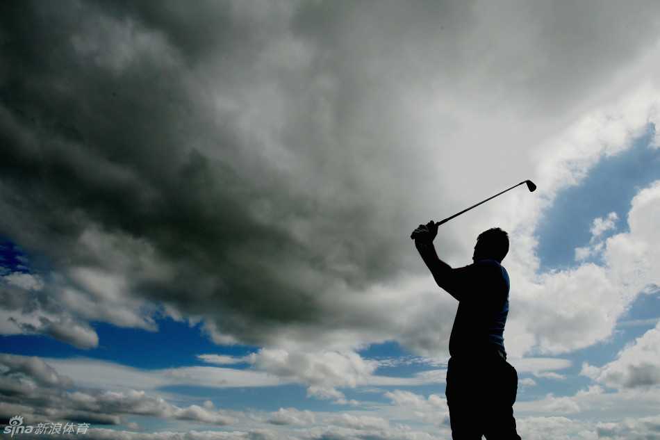 圣安德鲁斯老球场上空，湛蓝的天幕与絮状的白云构成一幅宁静的画面，古老的球场在阳光下延伸，诉说着高尔夫悠久的历史。