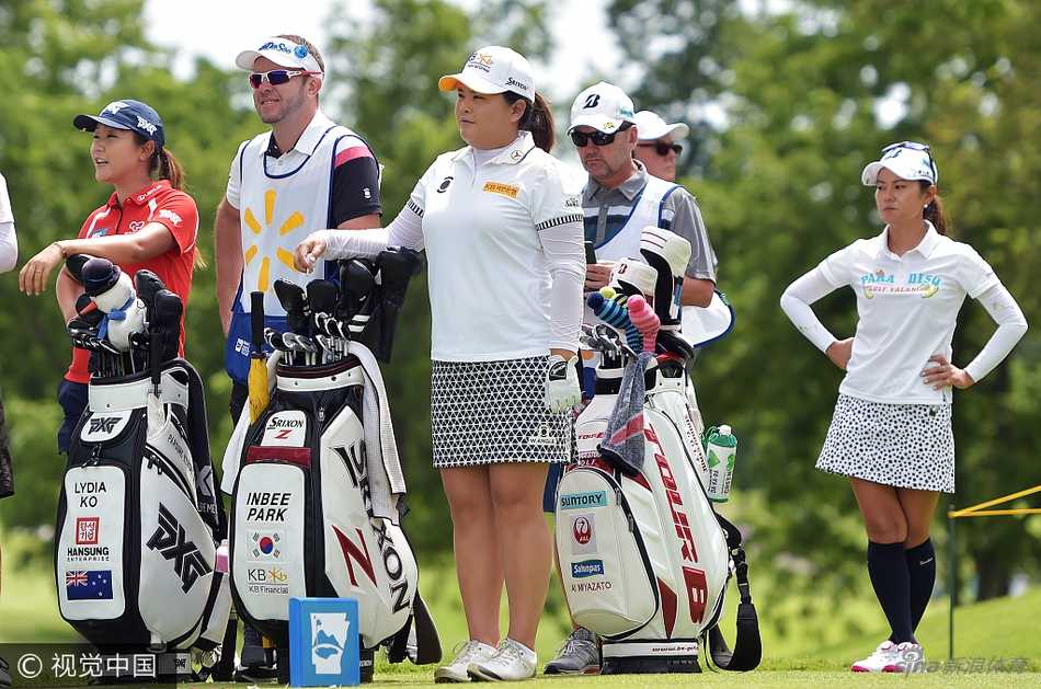 魏圣美佩戴着一条设计奇特而耀眼的项链，在赛场上低头审视高尔夫球，项链的独特造型与她的专注神情相映成趣。