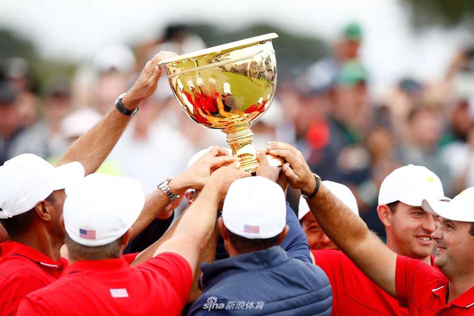 王者归来绝地反击 荣耀之战谱写传奇 美国队全体成员簇拥着金光闪闪的总统杯奖杯,队长泰格·伍兹位于人群中央,与队友们共同绽放出胜利的灿烂笑容。