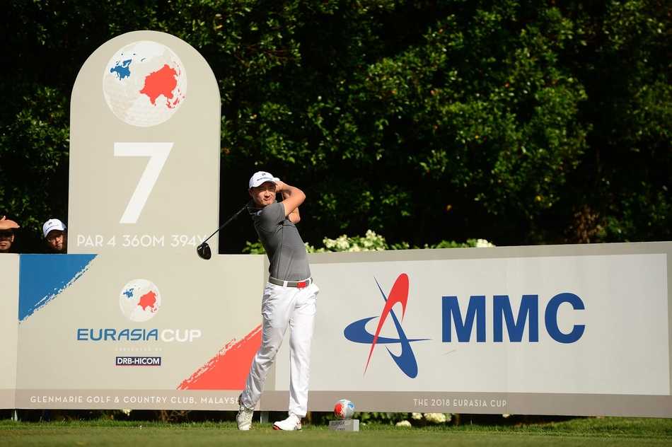 欧亚杯赛前风云:高尔夫悍将齐聚吉隆坡 欧亚杯赛场俯瞰图,巨大的赛事标志与绿意盎然的球道交相辉映,第7洞PAR4的挑战静待世界顶尖球手的征服。