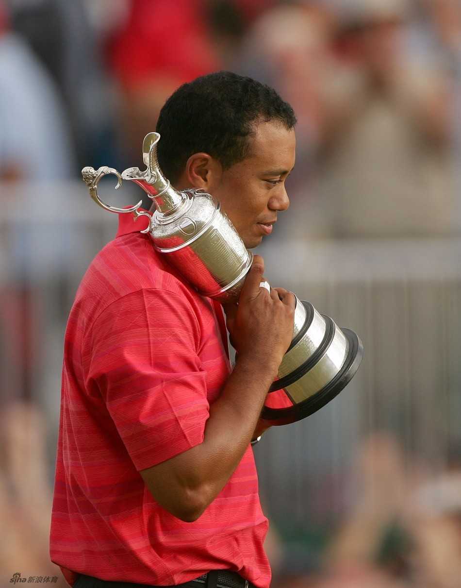 王者归来:伍兹的救赎之路 伍兹如欣赏珍宝般凝视奖杯,眼神中闪烁着胜利的喜悦与不易的感慨