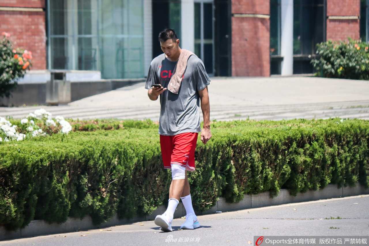 男篮领军者满血归队:易建联回归集训,重塑中国男篮之魂 在午后的烈日下,易建联身穿深色训练服独自走出球馆,他脖子上搭着的白色毛巾已被汗水浸透,膝盖上厚重的黑色护具清晰可见,尽管神情轻松,但每一步都透露出伤愈复出的谨慎与坚韧。