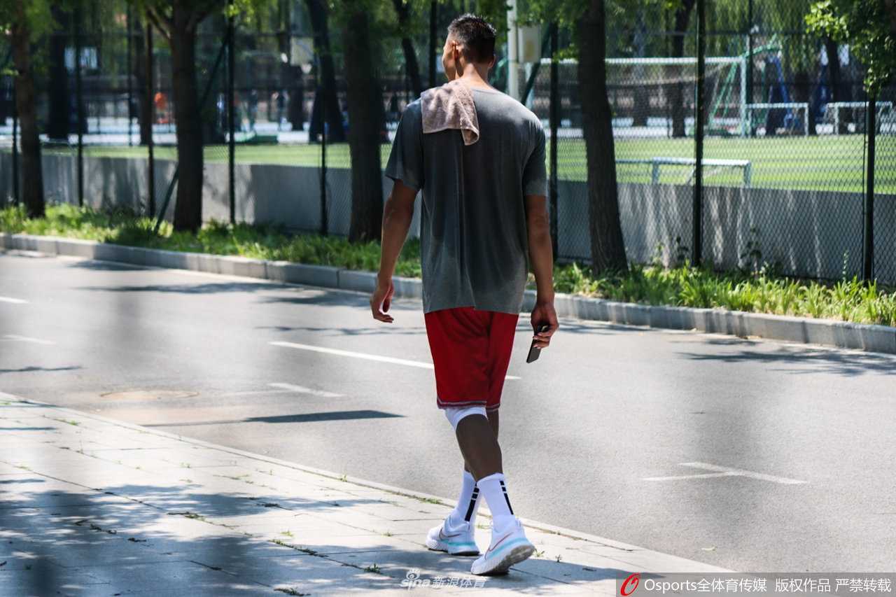 男篮领军者满血归队:易建联回归集训,重塑中国男篮之魂 训练馆内,易建联正在外线进行投篮练习,他高高跃起,手腕轻柔拨动,篮球在空中划出一道优美的弧线。背景中模糊的场馆设施更衬托出他动作的舒展与核心力量的强大。