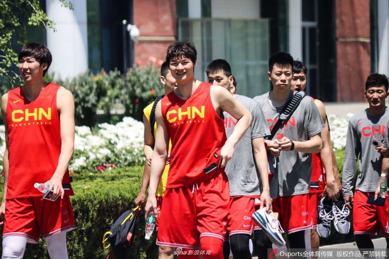 男篮领军者满血归队:易建联回归集训,重塑中国男篮之魂 易建联在训练后一边拿着水瓶补水,一边与身边的队友进行交流。汗水从他的额头滑落,嘴角带着一丝微笑,这一刻的老大哥没有距离感,只有并肩作战的亲切与信任。