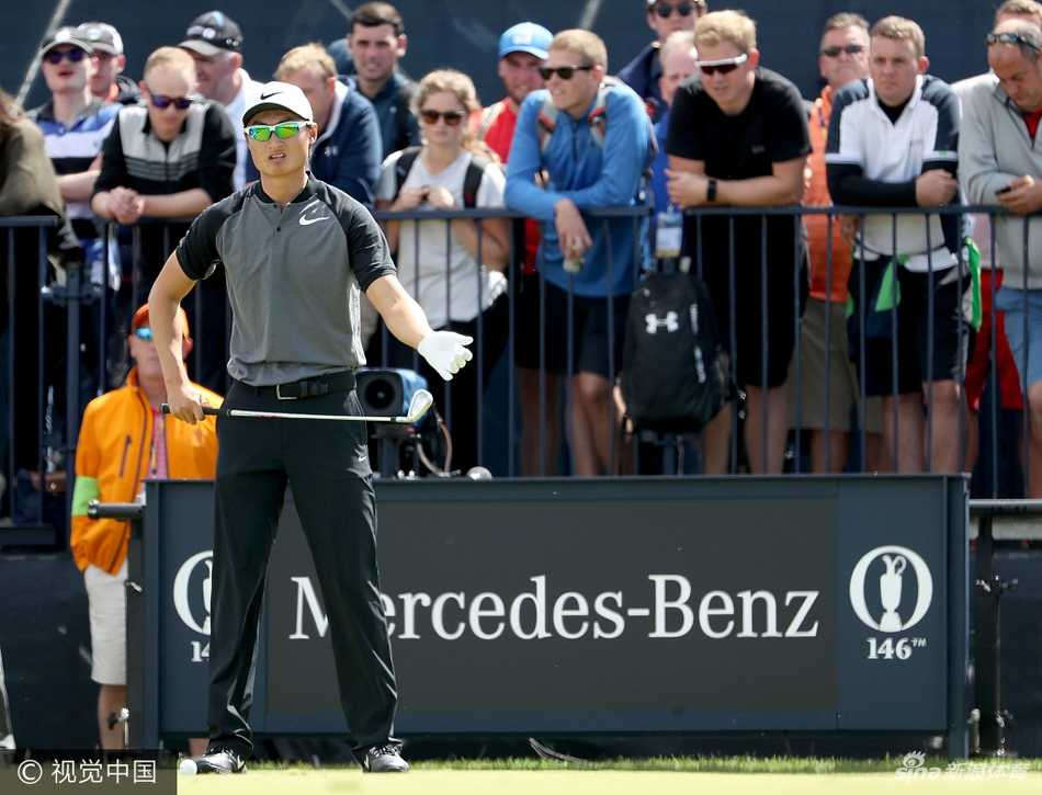 李昊桐在发球台上凝神准备开球，他身体微微前倾，目光如炬地审视着前方充满挑战的球道，全场观众都在屏息等待。