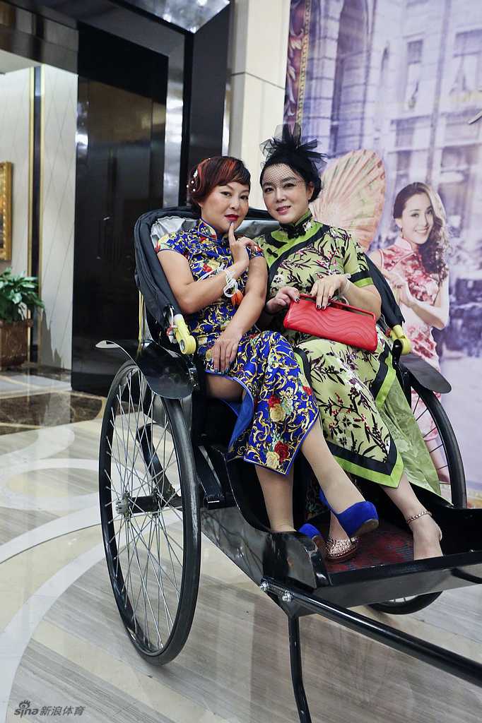 三位优雅的女士并肩而立，身着带有老上海元素的礼服，在复古背景前含笑合影，她们的姿态从容，仿佛刚结束一场华丽的宴会，正分享着彼此的趣事。