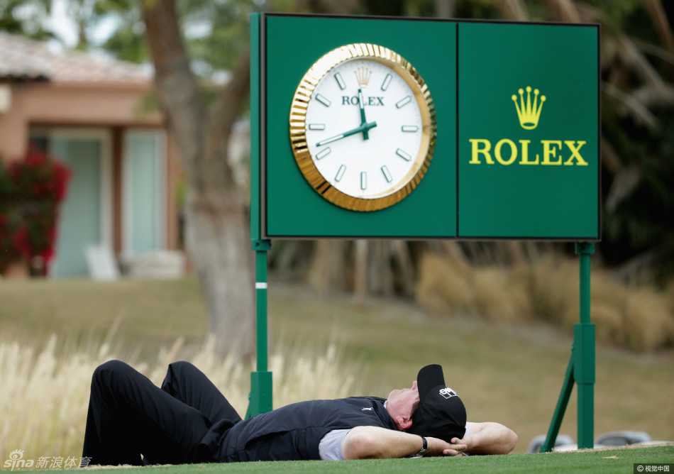老米在雨势中专注凝视前方，准备关键一击，腕间的劳力士表与湿漉的赛场形成鲜明对比，尽显沉稳风范。