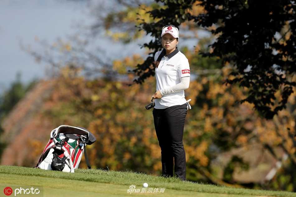 依云锦标赛赛场全景，绿草如茵的球道沿着山坡延伸，远处是波光粼粼的日内瓦湖，风景如画。