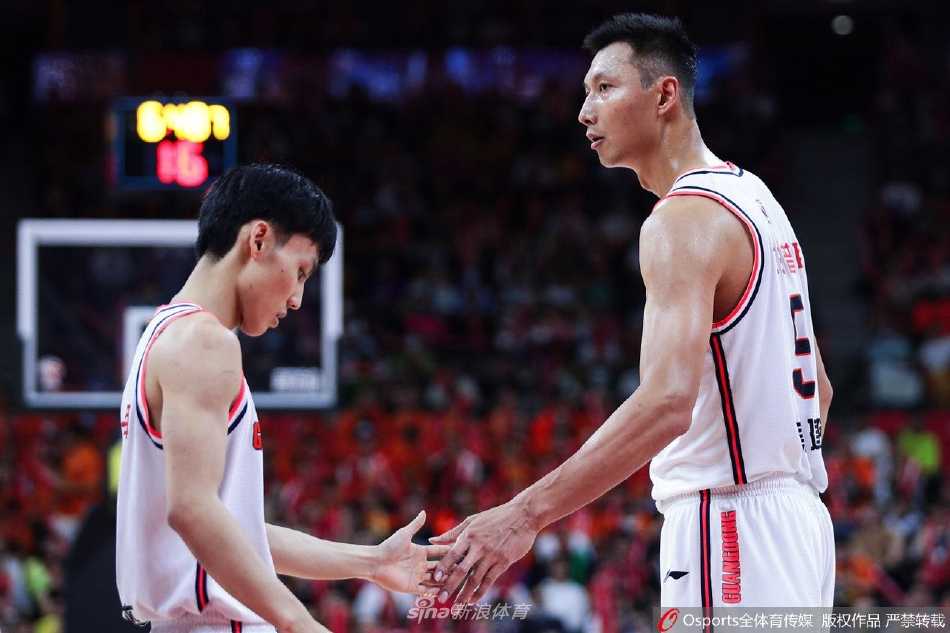 新疆外援塔克-法尔在广东内线群中高高跃起，凭借绝对身高优势完成一次轻松的投篮，背景是易建联与队友望球兴叹的身影。