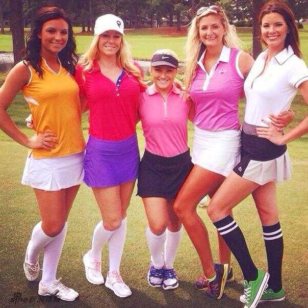 绿茵场上的智慧与风景记高尔夫球童的多元角色 四位女球童面带灿烂笑容,并肩站在开阔的球道上,身后是湛蓝的天空与连绵的果岭,充满活力。