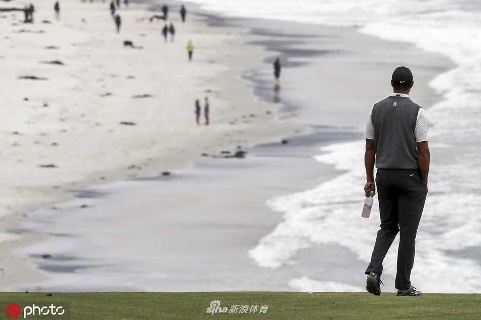 伍兹在练习果岭上专注练推，神情严肃，为大赛做最后准备