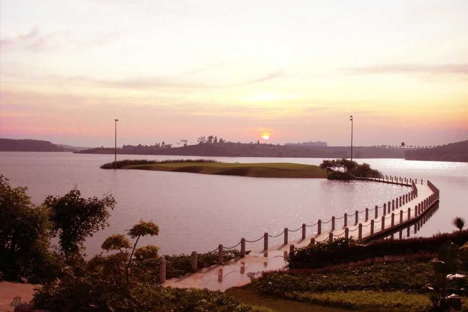 晨曦中的四号洞如翡翠项链镶嵌于湛蓝湖岸，倒影如画