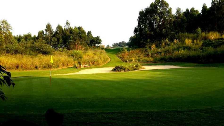 精悍球洞如微缩盆景，果岭似翡翠托盘盛着沙坑的金色花瓣