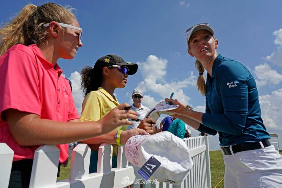 绿茵战场上的绽放与传承 艾米-奥尔森在果岭上露出标志性的温暖笑容,仿佛在享受比赛的每一刻。