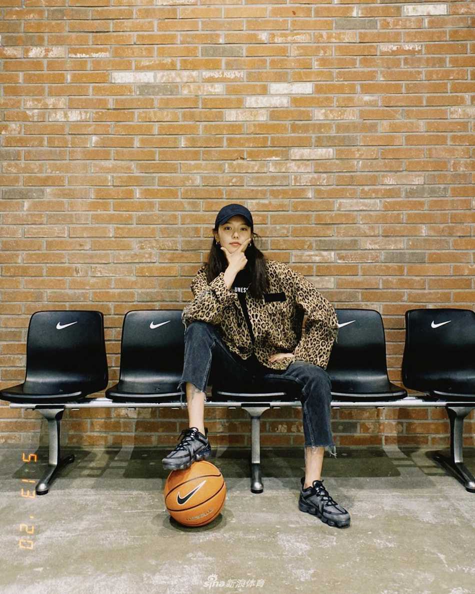 秀英完成挥杆后眺望球飞行的轨迹，身姿舒展挺拔，背景是开阔的蓝天与绿茵