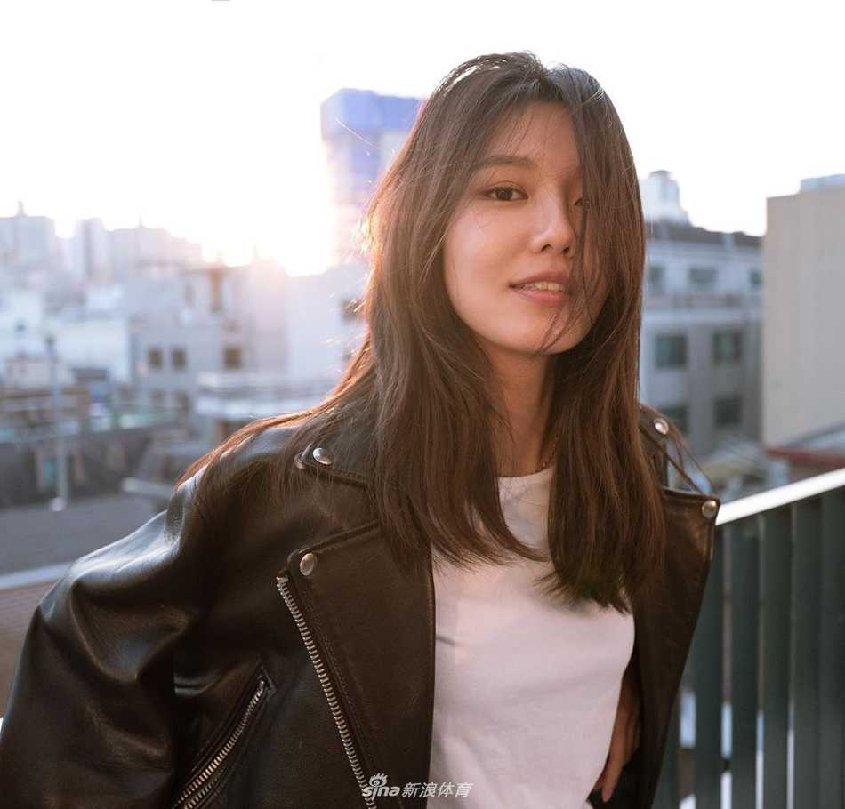 秀英漫步于翠绿球道，手提球杆悠闲前行，展现出运动后的放松与惬意