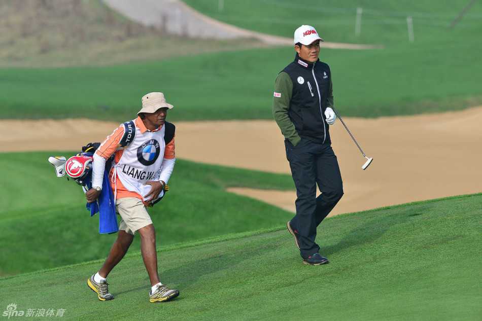 绿茵之上的凝望与挥洒中国高尔夫球手的专注瞬间 梁文冲在练习果岭边进行切杆训练,教练在一旁细致观察并提供即时指导,共同雕琢技术细节。