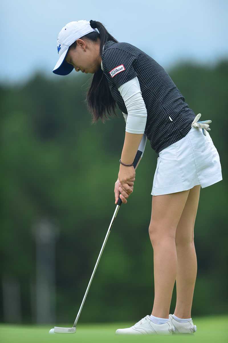 陈敏柔目光如炬，在果岭边完成一次优雅而有力的收杆动作，白色球帽下是写满专注的脸庞。