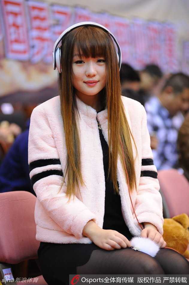 画面拉远，这位戴着时尚帽子的女球迷融入在蓝色的座椅海洋中，她是万绿丛中一点红，装点着这个属于篮球的夜晚。