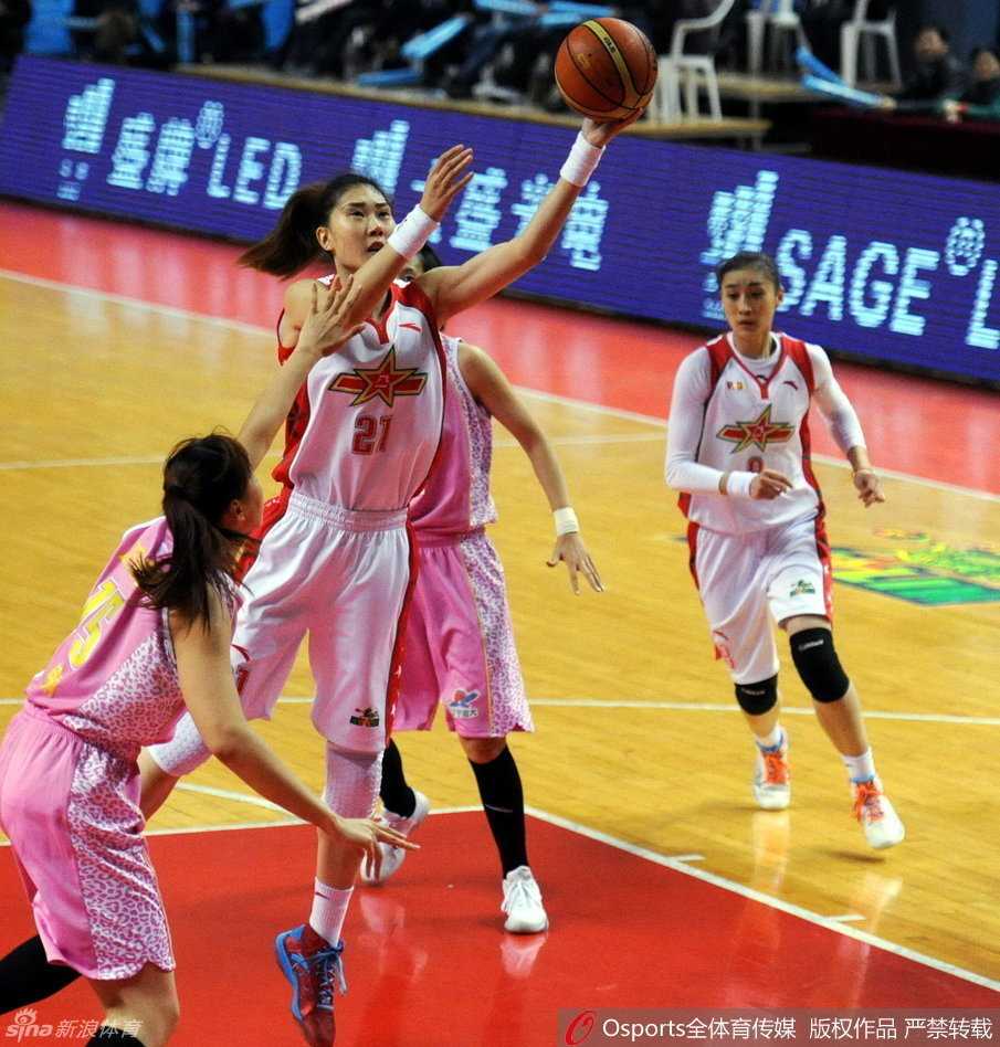 八一女篮队员高高跃起，单手将球送入篮筐，完成了一次标准而流畅的三步上篮。