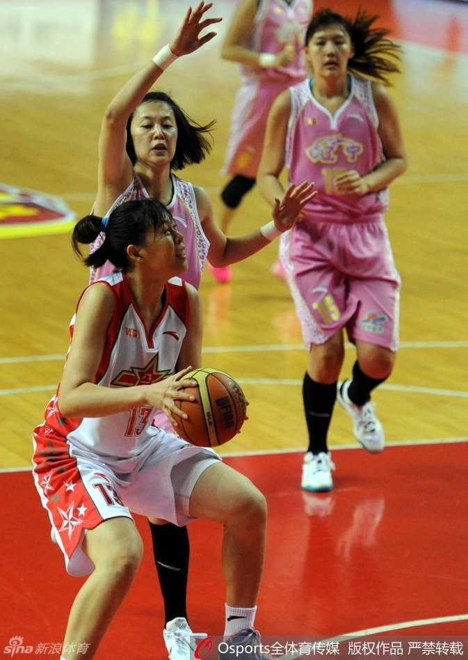 北京女篮核心邵婷在山西队两人高举起双臂的严密双人包夹下，寻找队友准备传球。