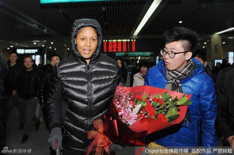 玛雅·摩尔微笑着拿出手机，与一位激动的中年男球迷进行自拍合影，身后的其他球迷也纷纷举起手机记录这追星时刻。