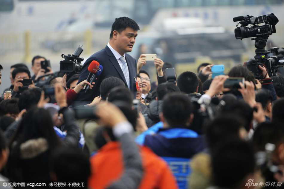 姚明一身正装走在代表委员中间，他微微侧身与身边的委员交流。在他身后，是庄严的人民大会堂，这一幕象征着体育人在国家政治生活中的深度参与。