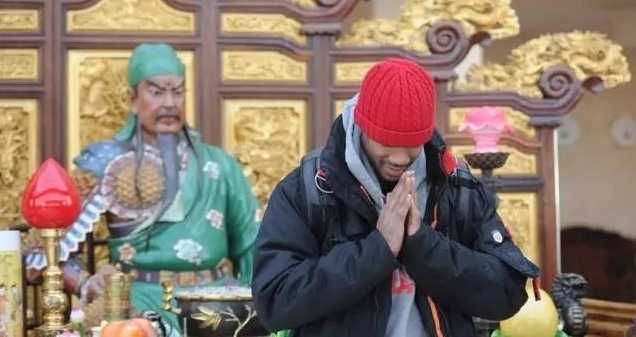 古色古香的关帝庙前，他学着国人的样子作揖祭拜，神情肃穆而真诚