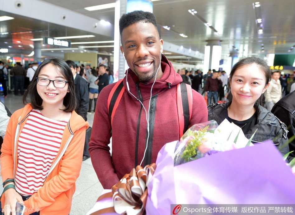 科尔微笑着与一位女球迷并肩站立，身体微微侧向镜头，眼神温柔，满足了这位粉丝合影的小心愿。