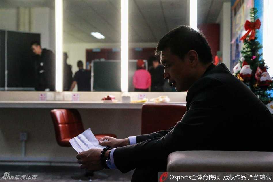 场边的孙悦虽然因伤未能出场，但他依然心系战局，穿着便服低头刷着手机，似乎在查找着什么信息，或许是想从数据中为场上的兄弟们找到一丝破解困局的线索。