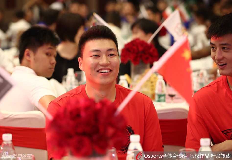 周琦嘴角上扬，露出标志性的腼腆笑容，眉眼间藏不住的开心感染了身旁的队友，仿佛将宴会厅变成了他的个人秀场。