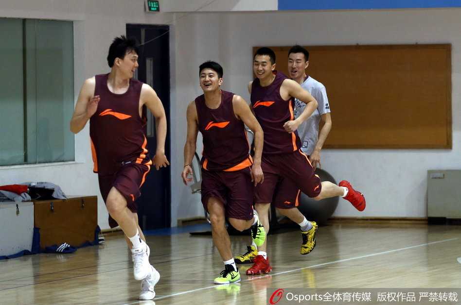 教练员正对着球员的动作进行细致入微的指导，他一只手扶着球员的腰部纠正发力姿势，另一只手比划着战术要点，神情极其严肃。