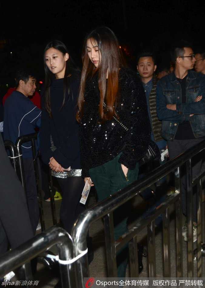 陈露双手自然垂放，身姿挺拔地站立于球场通道，背景是喧闹的看台，她却自成一道静谧风景。