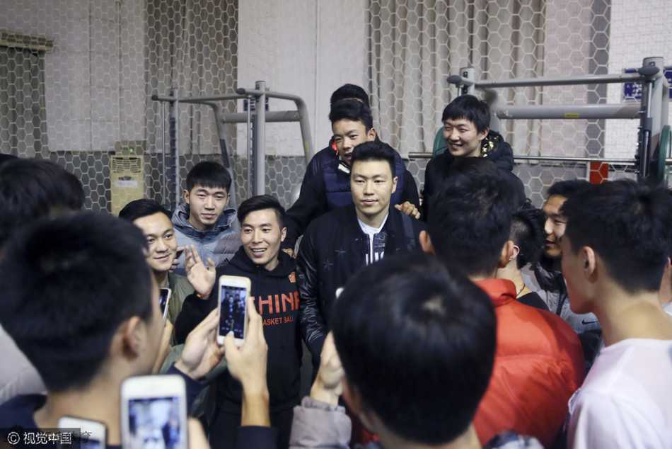 身披战袍的李根在球场边被热情的学生球迷团团围住，他面带亲和的笑容，耐心地为每一位粉丝签名，举手投足间尽显大将之风。