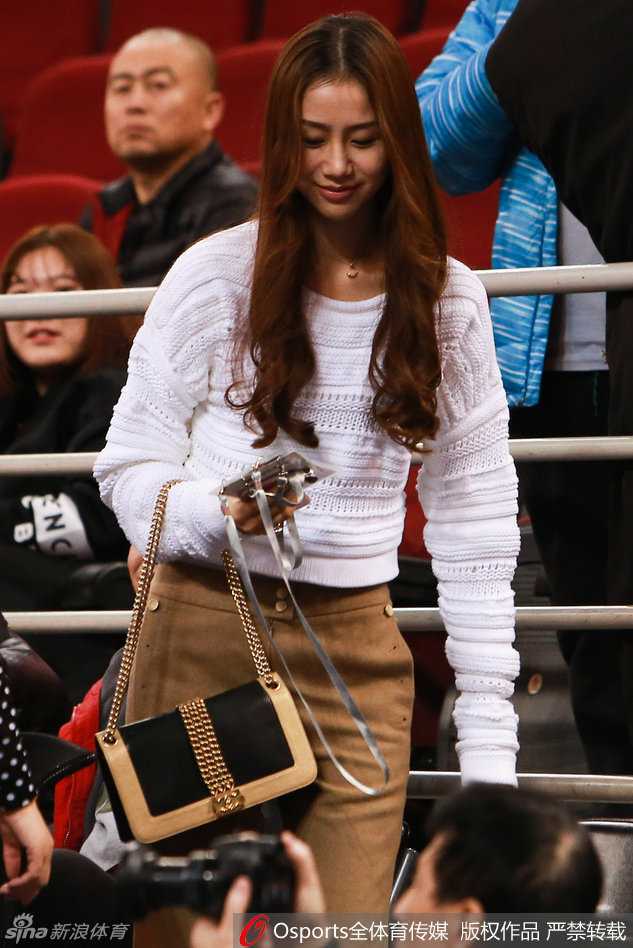 比赛间隙，心情放松下来的陈露展现出俏皮可爱的一面。她轻轻整理着秀发，眼神中带着一丝灵动，仿佛在与场上的爱人进行着无声的交流，这充满生活气息的一幕，瞬间融化了镜头的冰冷。