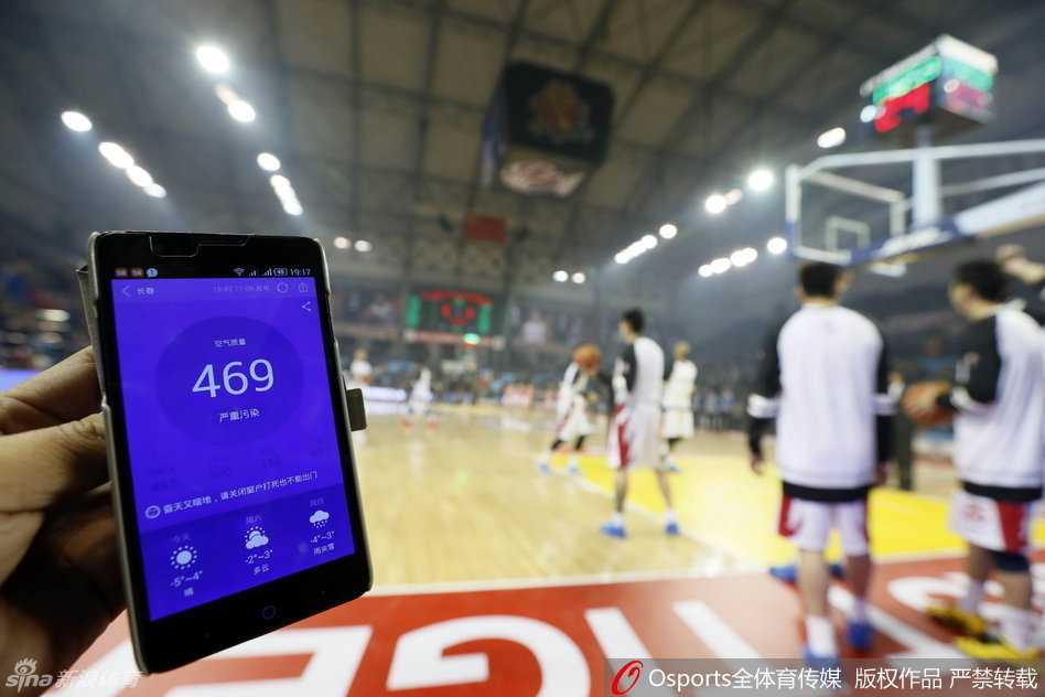 在弥漫着烟雾的球馆内，吉林队中锋钟诚眉头紧锁，高高举起球衣紧紧捂住口鼻，仿佛在无声地对抗着这看不见的“雾霾杀手”，眼神中透露出无奈与坚持。