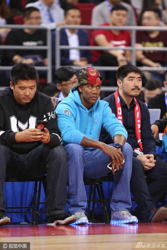 老马双手交叉置于身前，目光如炬地望向球场上的激烈拼抢，此刻他不仅是观众，更像一位在沉思的“政委”，琢磨着篮球的真谛。