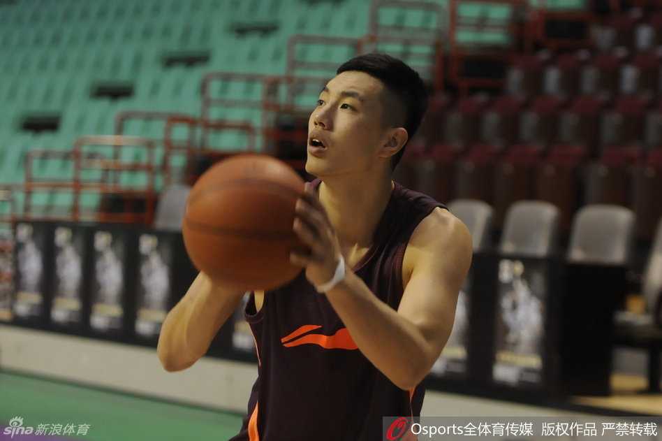 莫里斯坐在场边接受理疗师的治疗，胳膊的酸痛让他表情略显痛苦，但他目光坚定地望向远方正在训练的队友